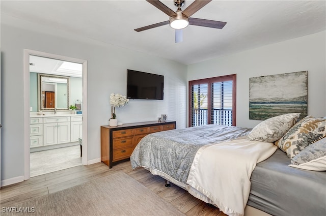 bedroom featuring ceiling fan, sink, light hardwood / wood-style floors, and ensuite bath