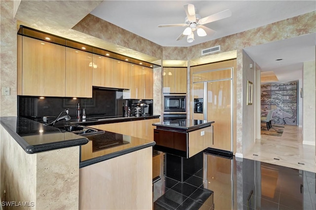 kitchen with built in appliances, light brown cabinetry, sink, kitchen peninsula, and ceiling fan