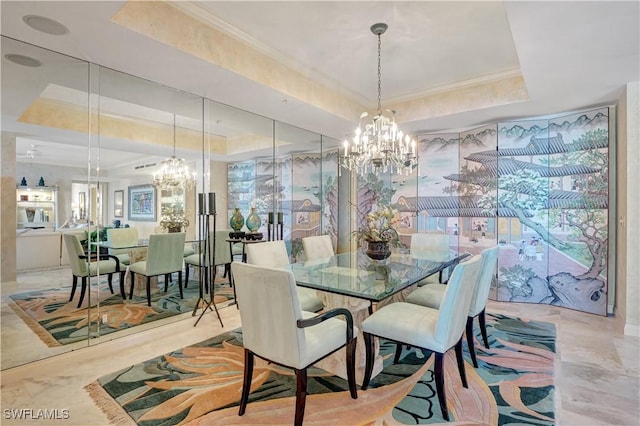 dining room featuring a notable chandelier, ornamental molding, and a tray ceiling