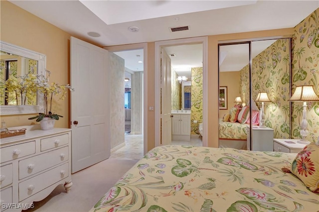 bedroom featuring light carpet, a closet, and connected bathroom