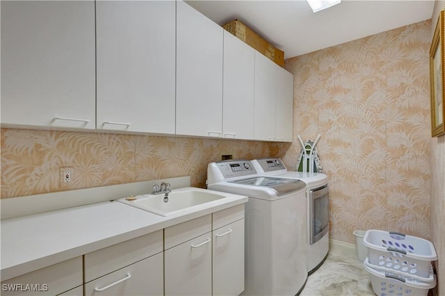 laundry room featuring cabinets, sink, and washer and clothes dryer