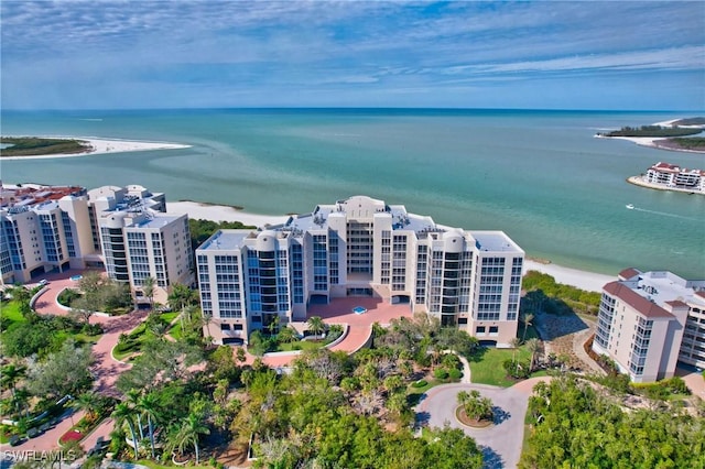 birds eye view of property featuring a water view and a beach view