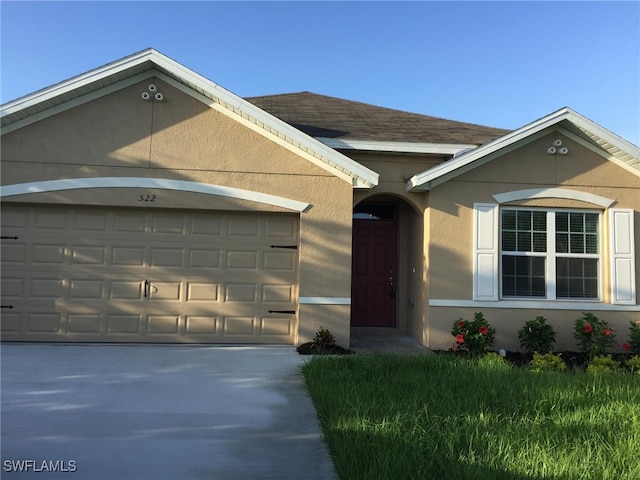 ranch-style house with an attached garage, a shingled roof, concrete driveway, and stucco siding