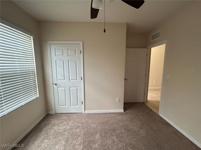 unfurnished bedroom featuring carpet, visible vents, ceiling fan, and baseboards