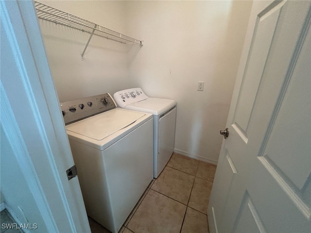 washroom with laundry area, light tile patterned flooring, and washing machine and dryer