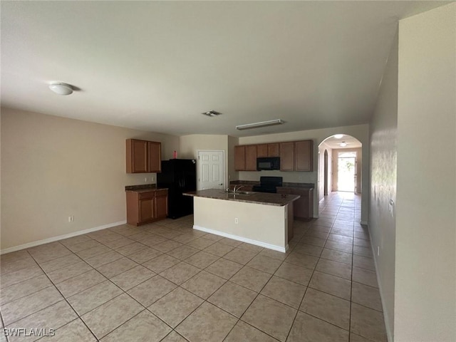 kitchen featuring visible vents, arched walkways, dark countertops, black appliances, and light tile patterned flooring