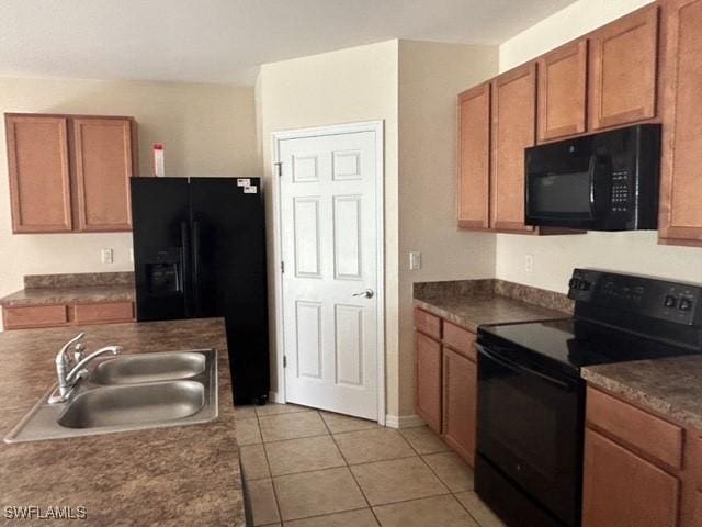 kitchen with black appliances, brown cabinetry, a sink, and light tile patterned flooring