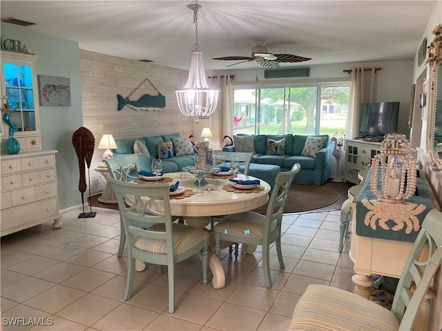 tiled dining space featuring ceiling fan with notable chandelier