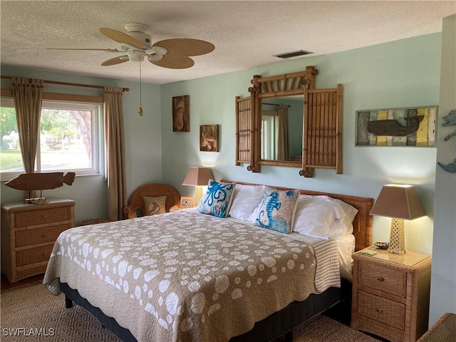 bedroom with ceiling fan and a textured ceiling