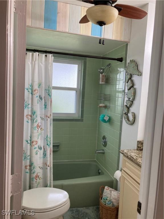 full bathroom featuring vanity, shower / bath combination with curtain, and toilet