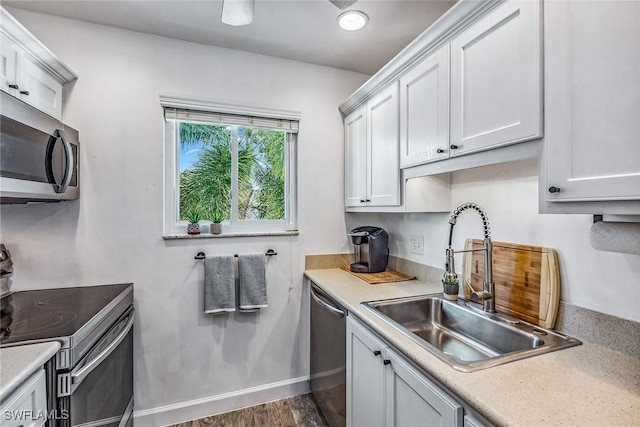 kitchen featuring dark wood-type flooring, white cabinets, appliances with stainless steel finishes, and sink