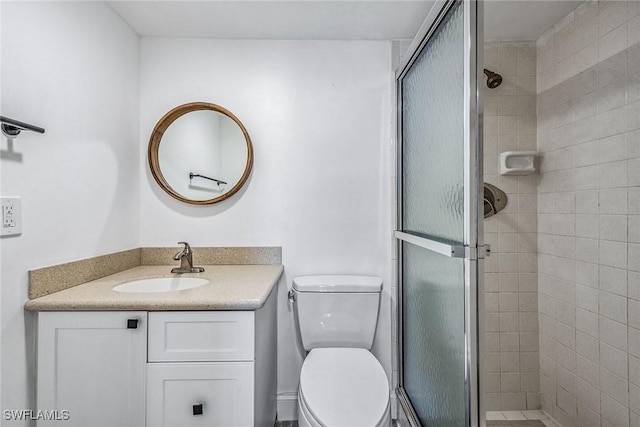 bathroom featuring toilet, vanity, and walk in shower