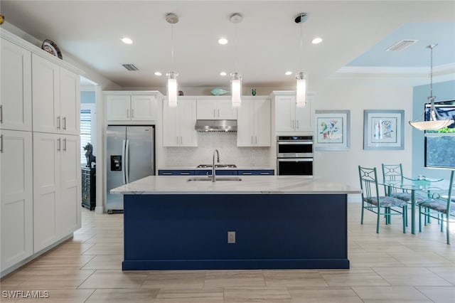 kitchen featuring an island with sink, white cabinets, and appliances with stainless steel finishes