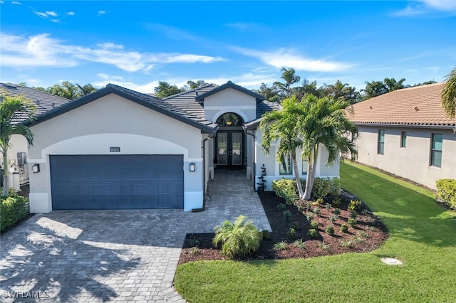 view of front of home with a garage, a front yard, and french doors