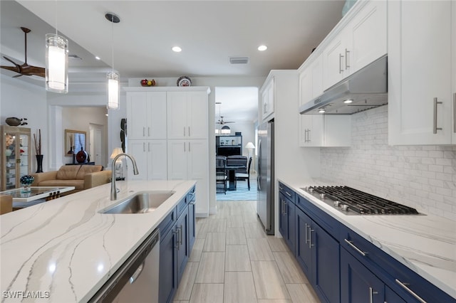 kitchen featuring blue cabinets, white cabinetry, hanging light fixtures, and sink