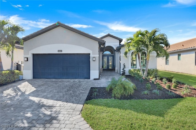 view of front facade with a garage, a front lawn, and french doors