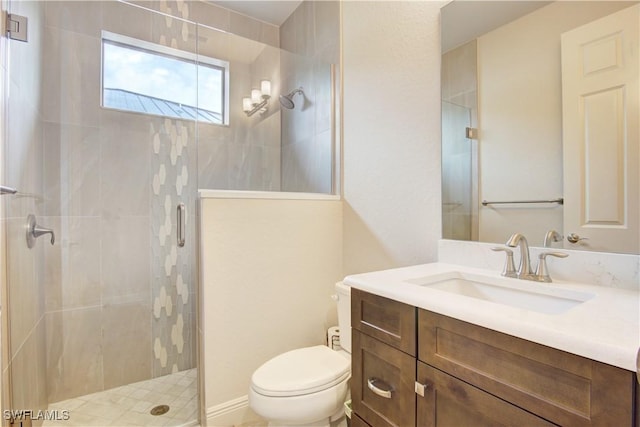 bathroom featuring vanity, toilet, and a shower with shower door