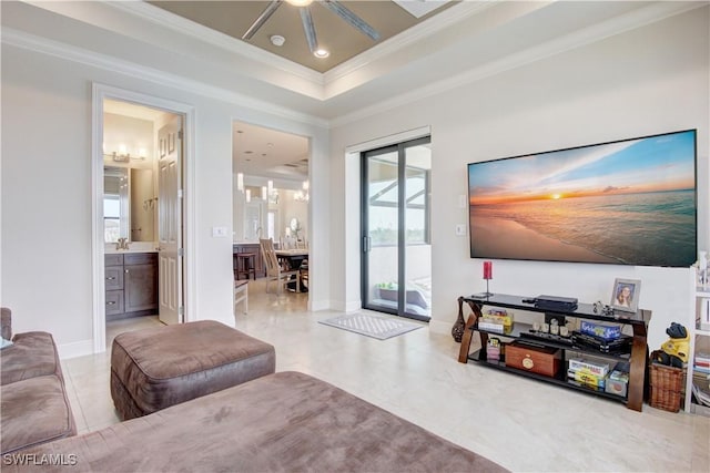 living room featuring ornamental molding, a tray ceiling, and sink