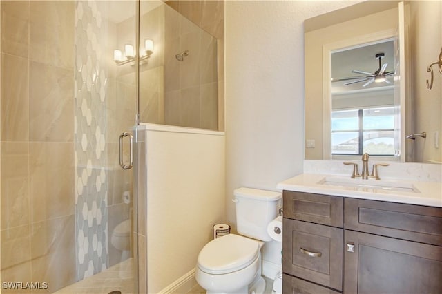 bathroom featuring an enclosed shower, vanity, toilet, and ceiling fan