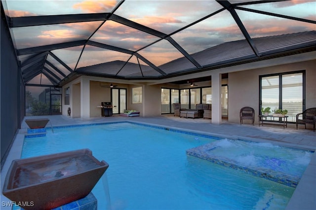 pool at dusk with ceiling fan, a lanai, an outdoor hangout area, and a patio area