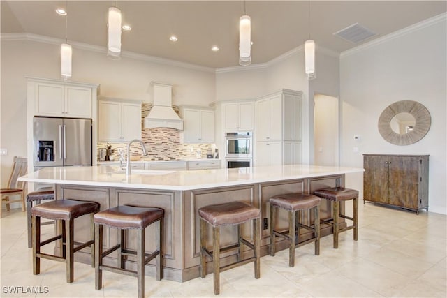 kitchen featuring custom exhaust hood, appliances with stainless steel finishes, a large island, and white cabinets