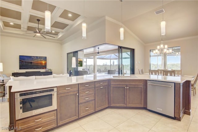 kitchen featuring sink, a center island, hanging light fixtures, appliances with stainless steel finishes, and ceiling fan with notable chandelier