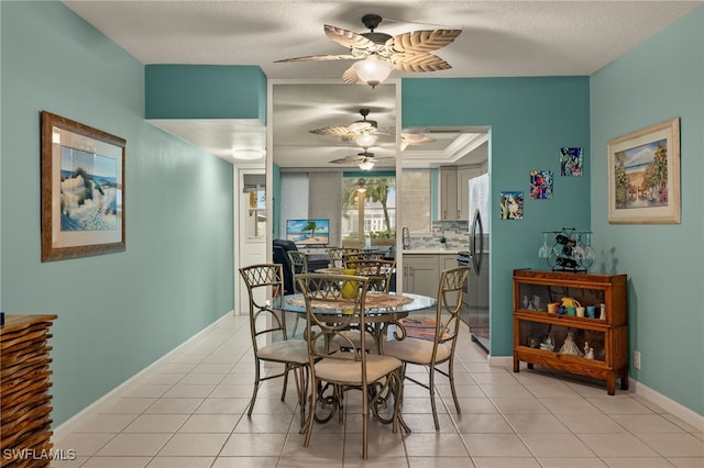 tiled dining space featuring ornamental molding, ceiling fan, and a textured ceiling