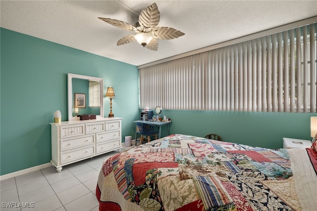 bedroom featuring a textured ceiling, ceiling fan, and light tile patterned flooring