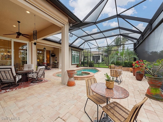 view of patio with an in ground hot tub, a lanai, and ceiling fan