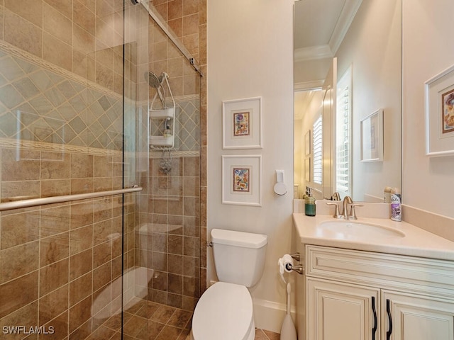 bathroom featuring crown molding, a shower with shower door, vanity, and toilet