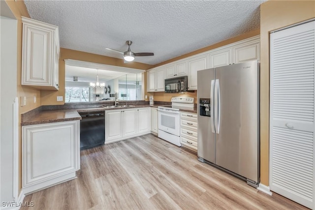 kitchen with dark countertops, white cabinets, a sink, and black appliances