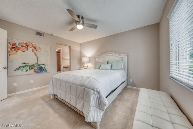 bedroom with light carpet, baseboards, visible vents, a ceiling fan, and a textured ceiling