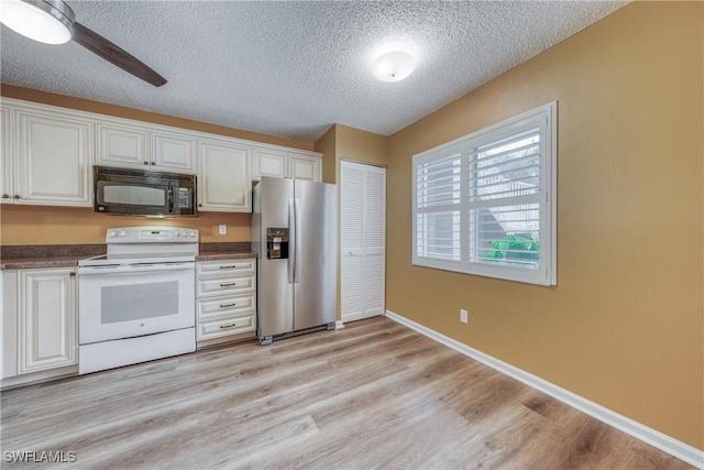 kitchen featuring white cabinetry, stainless steel fridge, black microwave, and electric range