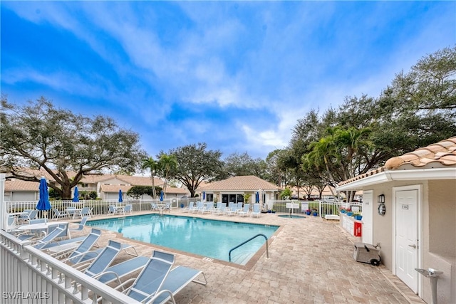 community pool with fence and a patio