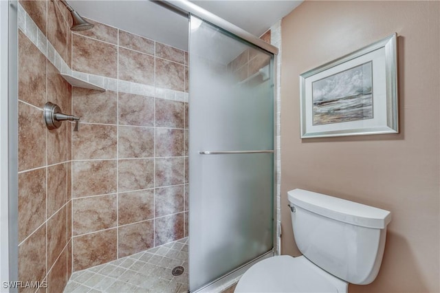 bathroom with a shower stall and toilet