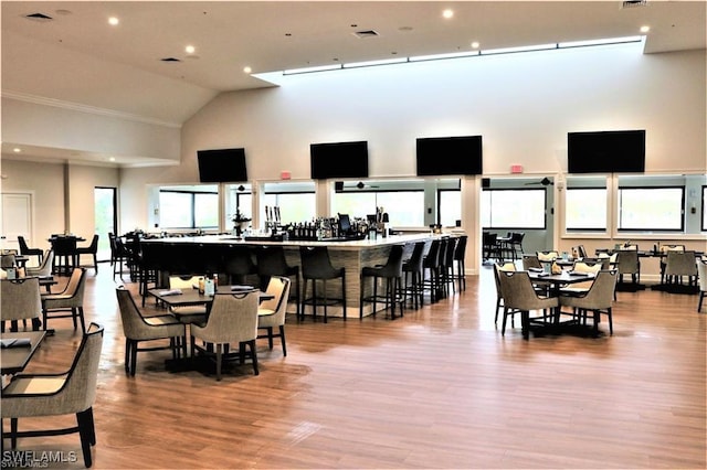 dining room featuring visible vents, a high ceiling, light wood-style flooring, and recessed lighting