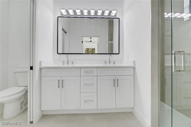 bathroom featuring vanity, a shower with shower door, and toilet