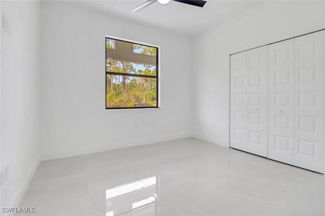 unfurnished bedroom featuring ceiling fan and a closet