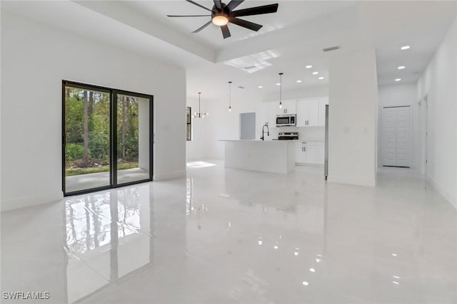 unfurnished living room featuring sink and ceiling fan