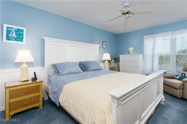 carpeted bedroom featuring a textured ceiling and ceiling fan