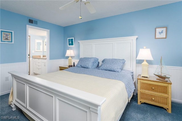 bedroom featuring dark carpet, connected bathroom, and ceiling fan