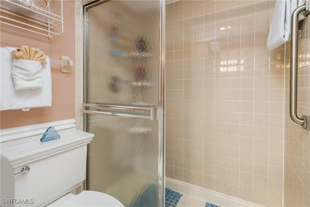 bathroom with toilet and an enclosed shower