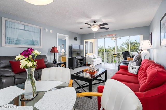 living room featuring ceiling fan and a textured ceiling