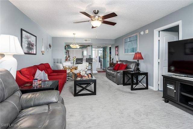 living room with light carpet, a textured ceiling, and ceiling fan