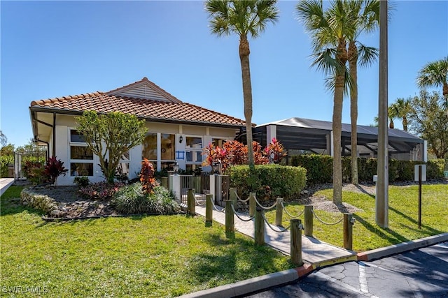 view of front of property featuring glass enclosure and a front yard