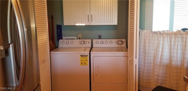 washroom with cabinets and washer and dryer