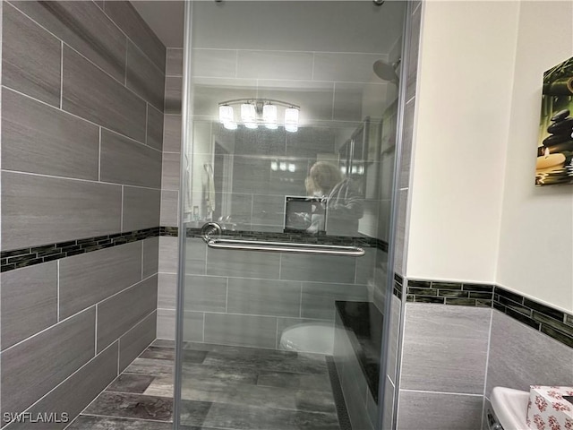 bathroom featuring walk in shower and tile walls