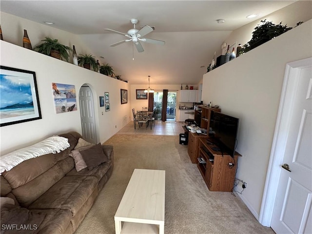 carpeted living room with ceiling fan and high vaulted ceiling