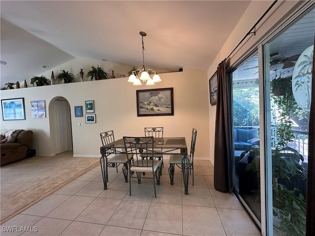 carpeted dining area with vaulted ceiling and a notable chandelier