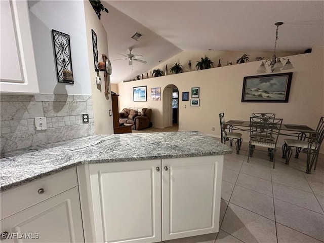 kitchen featuring light tile patterned flooring, light stone counters, vaulted ceiling, ceiling fan, and white cabinets